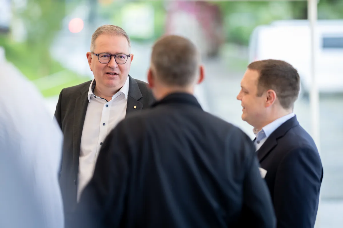 Mehrere Personen stehen zusammen und diskutieren. 